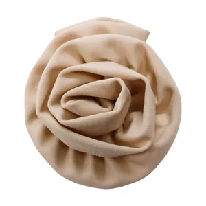 Vue détaillée d'une rose en tissu tridimensionnelle beige sur une robe de soirée