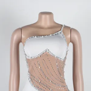 Dettaglio del vestito in rete trasparente con eleganti decorazioni in perle e strass.