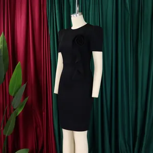Elegant black sheath dress with 3D floral and ruffle detailing on a mannequin