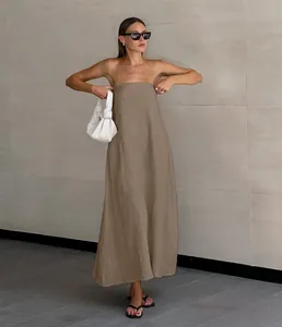Detailansicht des khakifarbenen trägerlosen Leinenkleides an einem Modell im Freien.