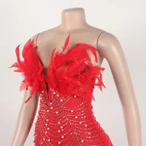 Detailansicht eines roten figurbetonten Partykleids mit Federn und Perlendekor