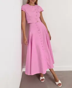 Vollansicht eines eleganten rosa Zweiteilers mit geknöpftem Oberteil und Midi-Rock.