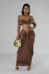 Elegant brown two-piece set featuring off-shoulder crop top and pleated floor-length skirt