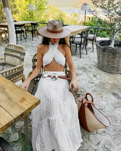 Elegant white Bohemian lace maxi skirt styled in a scenic sunny outdoor cafe setting