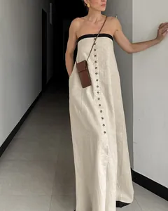 Elegant French style beige linen tube dress featuring black trim and decorative buttons