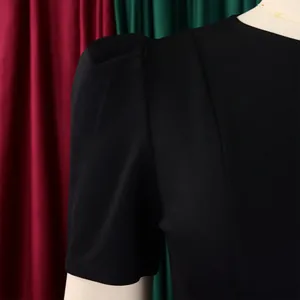 Close-up detail of elegant black dress featuring stylish puff sleeve shoulder design