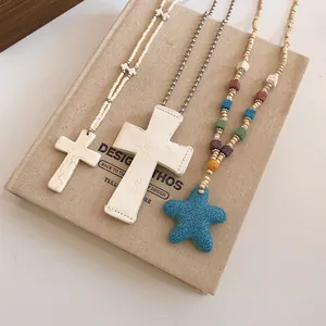 Detailed view of bohemian style beaded cross and starfish necklaces with unique textures