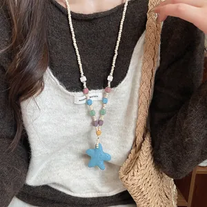 Detail shot of bohemian stone beaded necklace with a blue starfish pendant