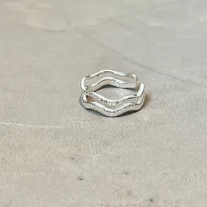 Detailansicht eines silbernen doppellagigen Wellenrings mit funkelnden Zirkonia