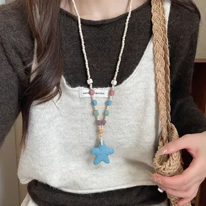 Close-up of bohemian beaded necklace featuring colorful stones and a blue starfish pendant.