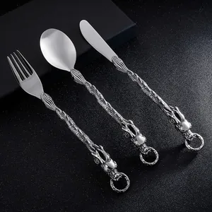 Dettaglio dei manici in acciaio inox con sbalzo a forma di drago in stile cinese.