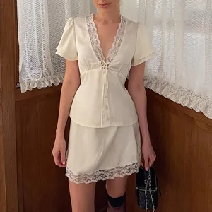 Detailed view of the lace patchwork on this elegant cream satin two-piece skirt set.