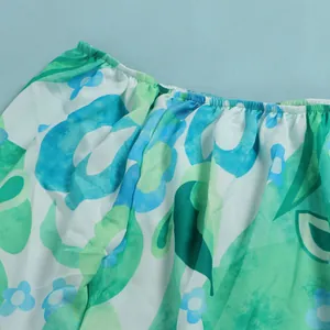 Close-up of vibrant blue and green floral print fabric with elastic waistband detail