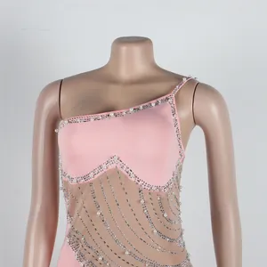 Dettaglio di un abito in rete rosa monospalla con eleganti perle e strass luccicanti