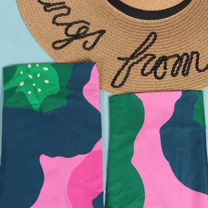 Detailed view of the vibrant green pink and blue abstract pattern on a summer dress