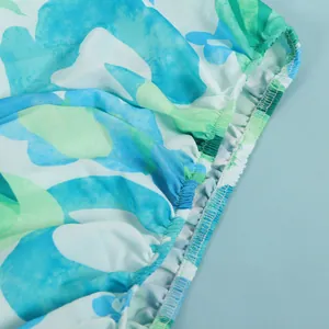Macro view of elasticated waistband detailing on a blue and green floral print dress