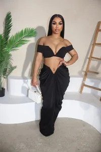 Close-up detail of a black off-shoulder pleated two-piece set with floor-length skirt