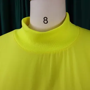Macro detail of a neon yellow chiffon dress featuring a ribbed mock neck collar design