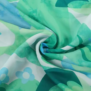 Macro shot of green and blue floral print fabric showing fine textile texture