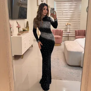 Elegante vestido maxi negro ajustado con brillantes patrones de pedrería y manga larga