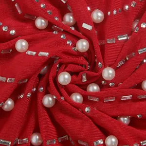 Makroaufnahme von rotem Netzstoff mit eleganten Perlen- und Strasssteinverzierung