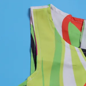 Close-up of vibrant wavy print fabric and neckline stitching on a sleeveless dress