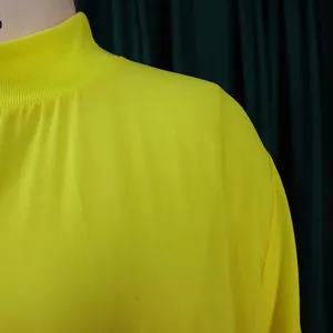 Close-up of yellow high-neck chiffon dress showing neckline and shoulder detail.