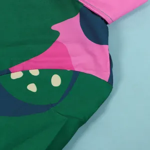 Macro view of the vibrant geometric pattern and fabric texture of this slim V-neck dress.