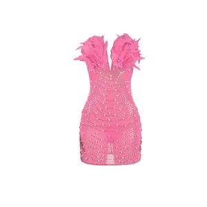 Detailansicht des rosa Bodycon-Kleides mit Straußenfedern und Perlenapplikationen.
