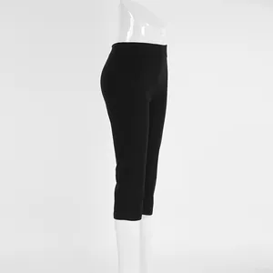 Detailed side view of high-waisted black cropped yoga pants on a white mannequin