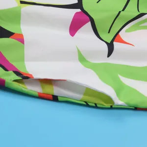 Close-up macro detail showing tropical leaf print and pocket seam on a floral slim dress