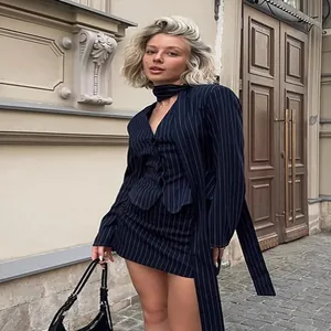Elegant navy pinstripe halter blazer and mini skirt set for women in urban setting.