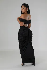 Back view of a black two-piece set featuring a ruched maxi skirt and off-shoulder top