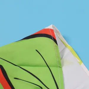 Close-up detail of the precise stitching and vibrant green print on a sleeveless dress.