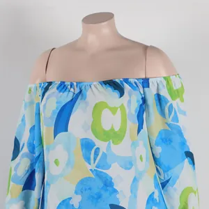 Detailed view of the off-the-shoulder elastic neckline on a blue and green floral dress
