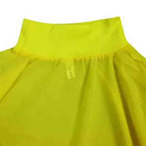 Close-up detail showing the vibrant yellow chiffon dress neckline and ribbed fabric texture