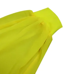 Close-up detail of vibrant yellow chiffon dress fabric with ribbed knit cuff texture