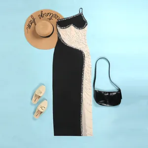 Elegante abito lungo in rete nera e beige con dettagli di perle e decorazioni in strass