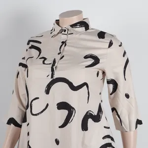 Close-up of beige shirt dress with black abstract squiggle print and lapel collar