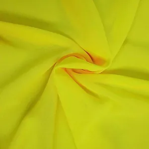 Detailed macro shot of bright neon yellow chiffon fabric texture and soft drape folds