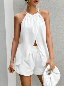 Detail of white halter neck top with slit front and matching shorts set on model