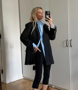 Model wearing black high-waisted cropped yoga leggings with oversized blazer outfit