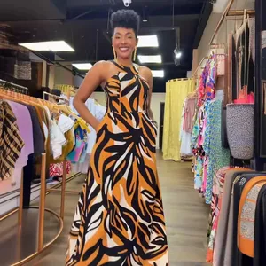 Sleeveless halter slim maxi dress with vibrant abstract leaf print in orange and black