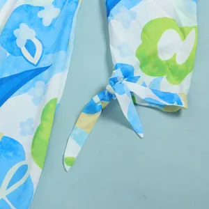 Detailed close-up of a blue and green floral print dress with an elegant tie-knot cuff