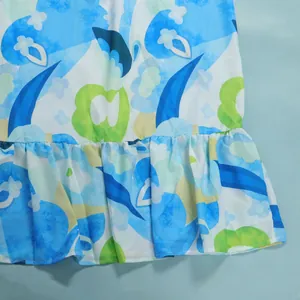Detailed macro view of vibrant blue and green floral print dress showing ruffle hem detail