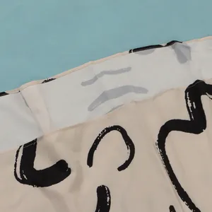 Detailed macro view of abstract black brush stroke pattern on soft beige fabric dress