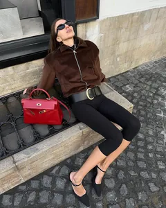 Outdoor lifestyle shot of high-waisted black capri yoga leggings with a tight fit.