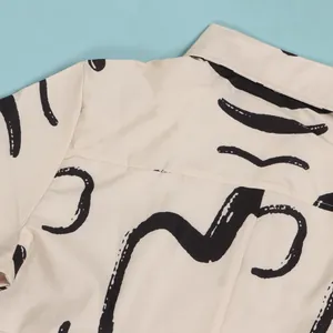 Close-up detail of abstract black brushstroke pattern on cream lapel dress back section