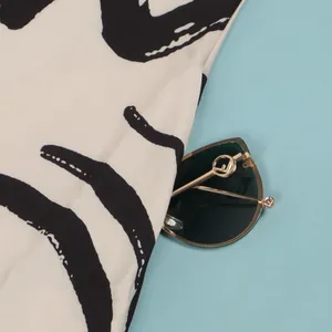 Macro detail of a slim-fit V-neck dress with black and white abstract wave print