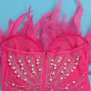 Nahaufnahme eines pinken Bodycon-Kleids mit Federn, Strasssteinen und Perlen-Applikationen